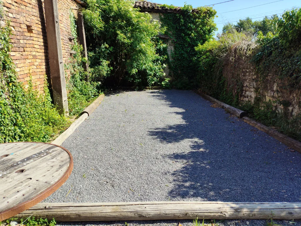 Allée extérieure ombragée et jardin verdoyant entourant la propriété