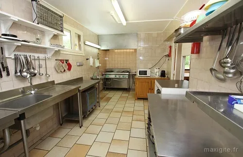 Cuisine professionnelle équipée avec grand plan de travail pour cuisiner en groupe