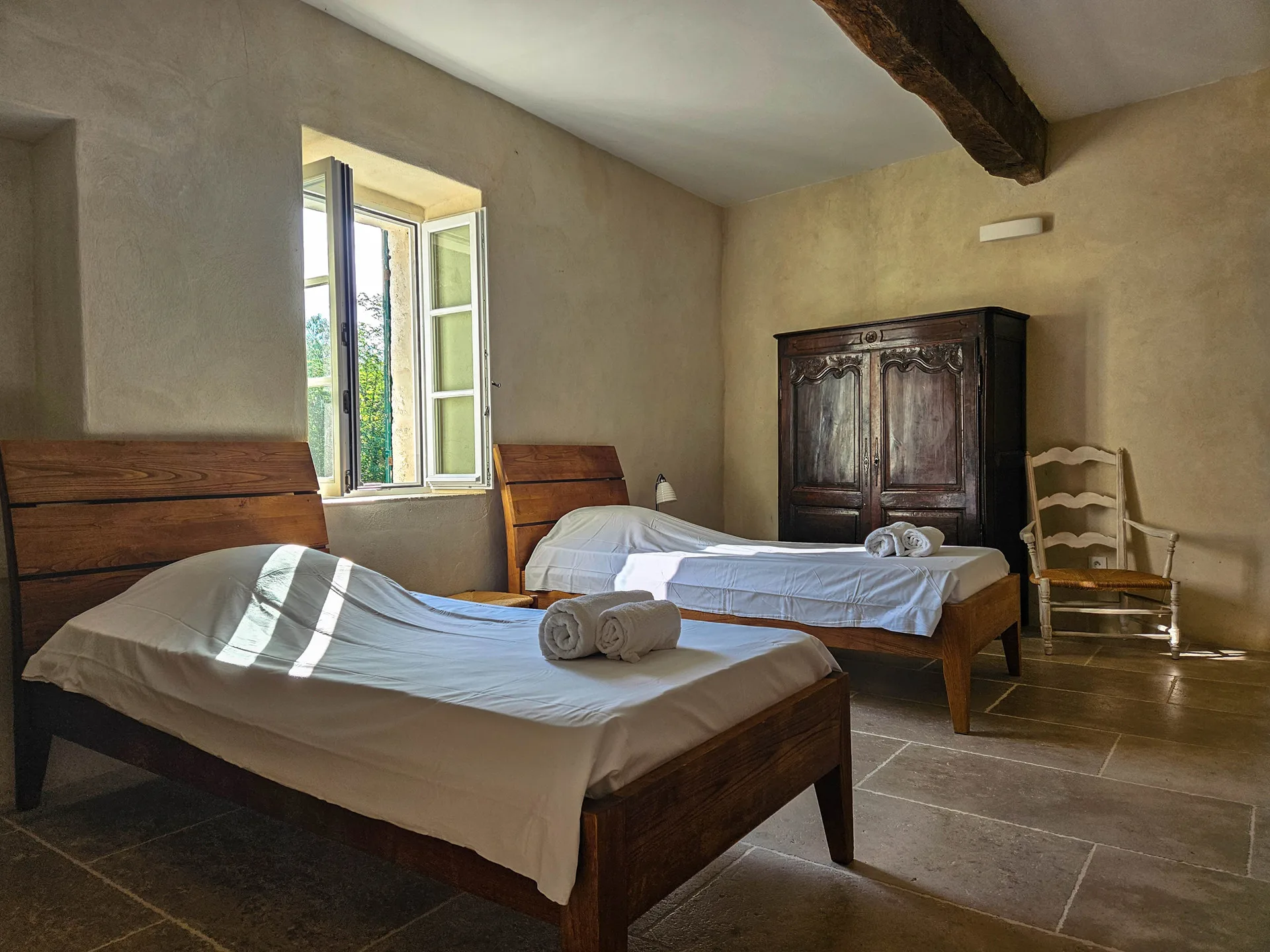 Chambre lumineuse du premier étage avec lits et poutres apparentes
