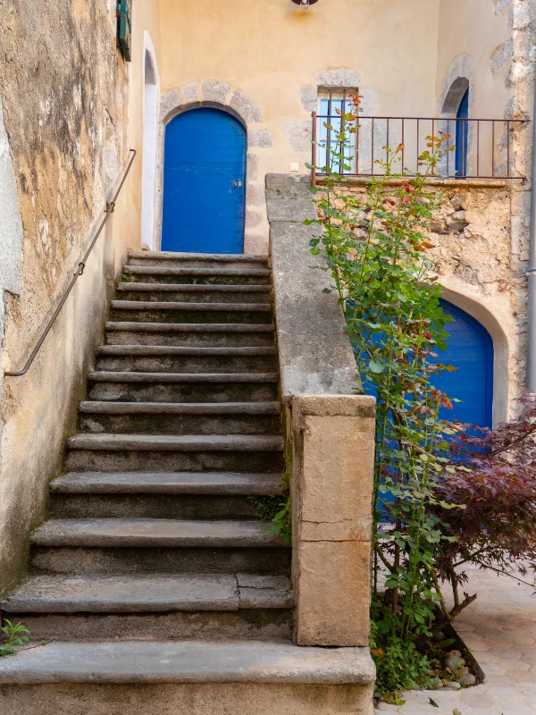 Patio intérieur en pierre avec vue sur les toits en tuiles du mas