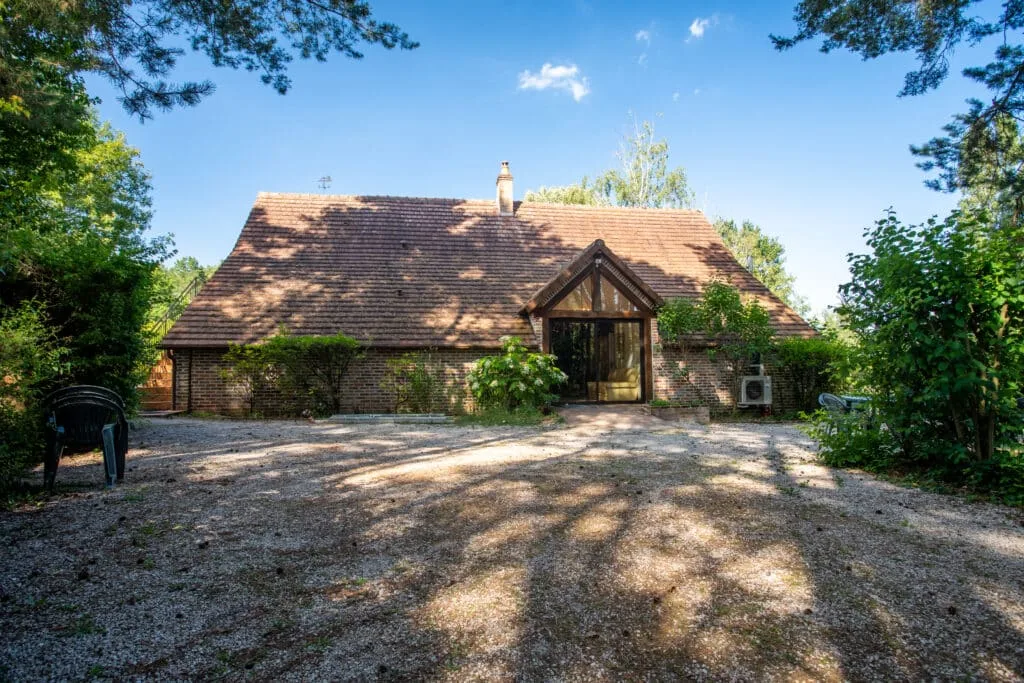 Gîte de groupe La Rosellerie à Montrieux-en-Sologne — Façade du domaine La Rosellerie en brique sous ciel bleu, entourée de végétation en Sologne, capacité 30 personnes