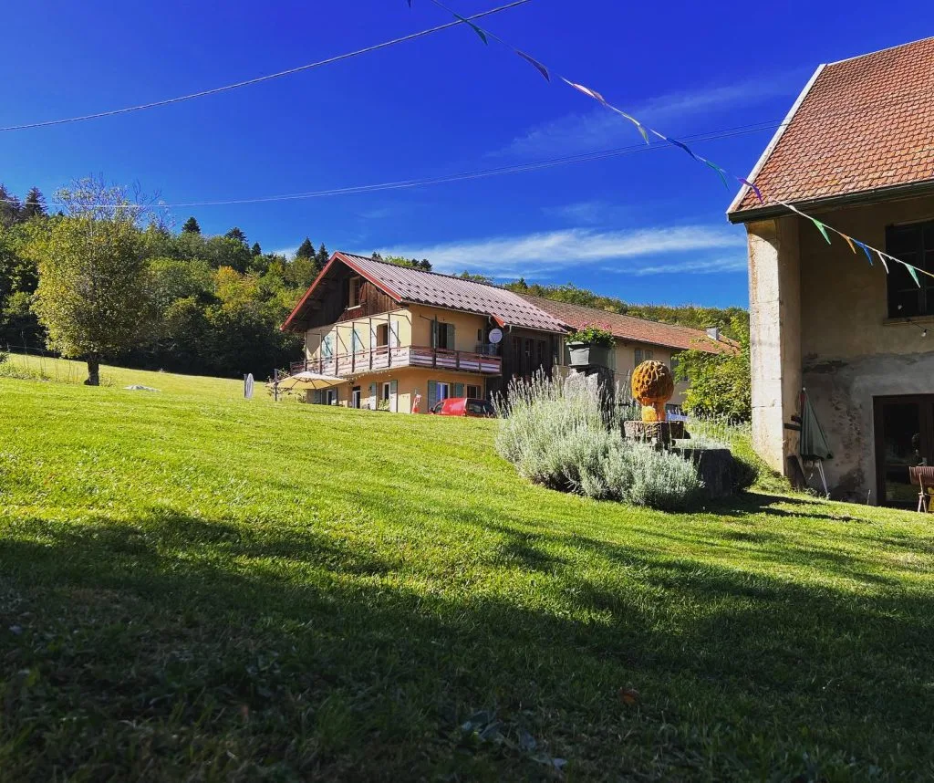 Gîte de groupe Domaine Pré-Jeantet à Valserhône — Vue extérieure du Domaine Pré-Jeantet à Valserhône avec bâtiments et prairie verdoyante, capacité 52 personnes