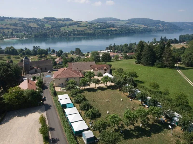 Vue aérienne du Centre Bellevue avec bâtiments, parc arboré et lac de Paladru en arrière-plan