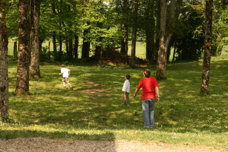 Famille se promenant dans le parc arboré et verdoyant du Centre d'Accueil de Benoîte-Vaux