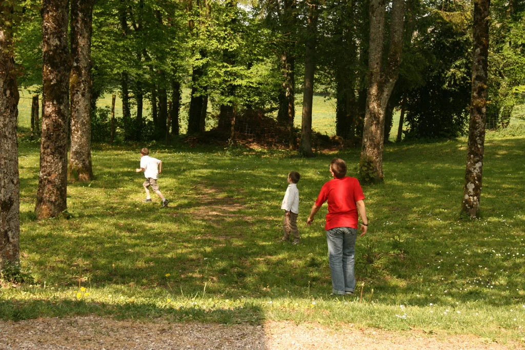 Famille se promenant dans le parc arboré et verdoyant du Centre d'Accueil de Benoîte-Vaux