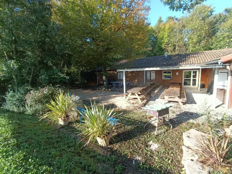 Terrasse extérieure couverte avec tables de pique-nique en bois vue Vercors