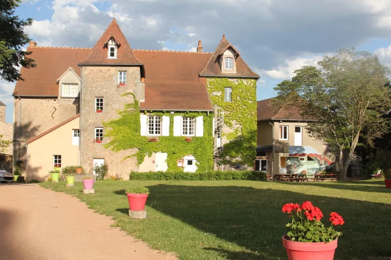 Façade arrière du Manoir La Grand'Cour à Lenax dans l'Allier, entourée de verdure