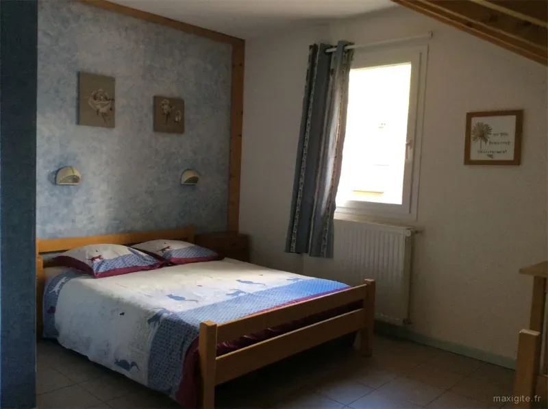 Chambre double avec décoration régionale et fenêtres sur le parc du gîte