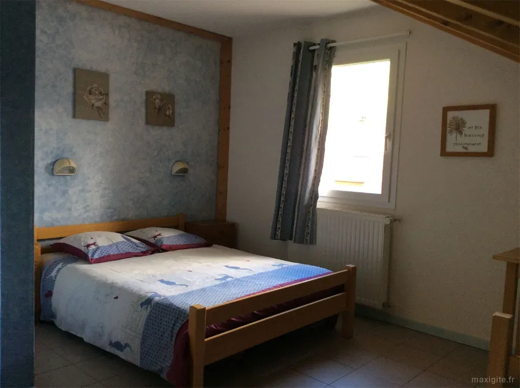 Chambre double avec décoration régionale et fenêtres sur le parc du gîte