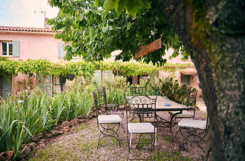 Terrasse extérieure avec mobilier en fer forgé et table pour les repas en plein air