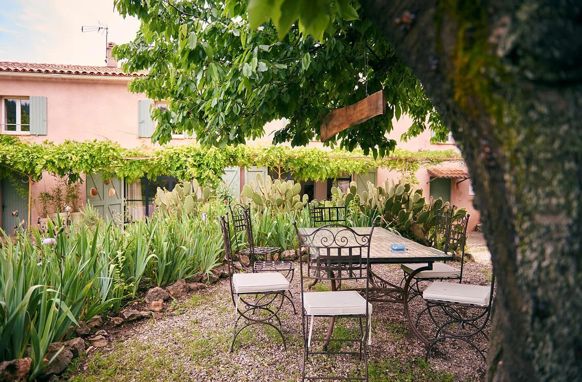 Terrasse extérieure avec mobilier en fer forgé et table pour les repas en plein air