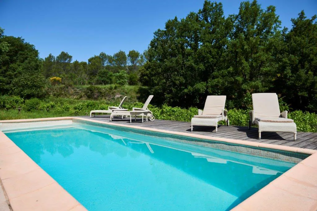 Piscine extérieure privée du domaine avec transats et végétation méditerranéenne