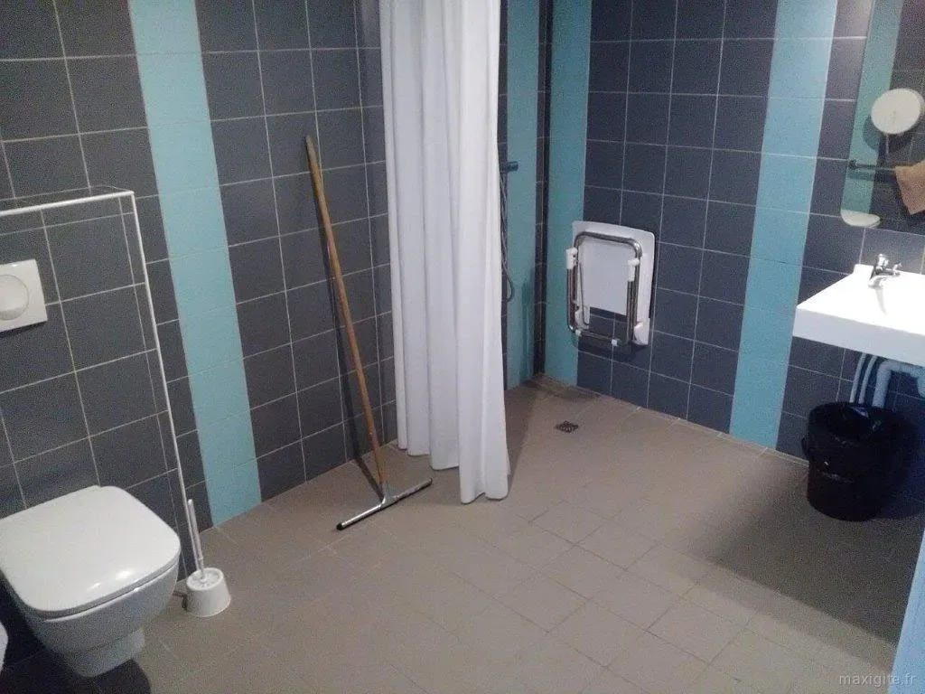 Sanitaires avec WC suspendu, douche à l'italienne et lavabo, carrelage gris et bleu