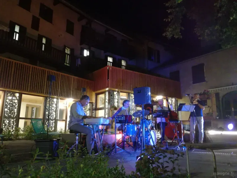 Concert de musique live en soirée dans la cour extérieure du centre CapVerb