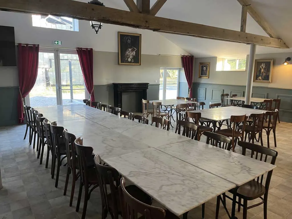 Grande salle de repas avec longues tables en marbre et chaises bistrot