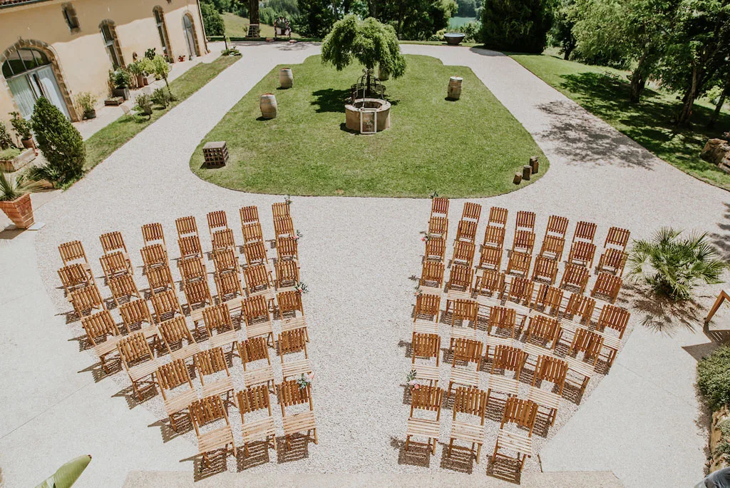 Gîte de groupe Château Lacoste à Lupiac — Vue aérienne de la cour d'honneur avec rangées de chaises en bambou disposées en arc sur la pelouse verte, capacité 60 personnes