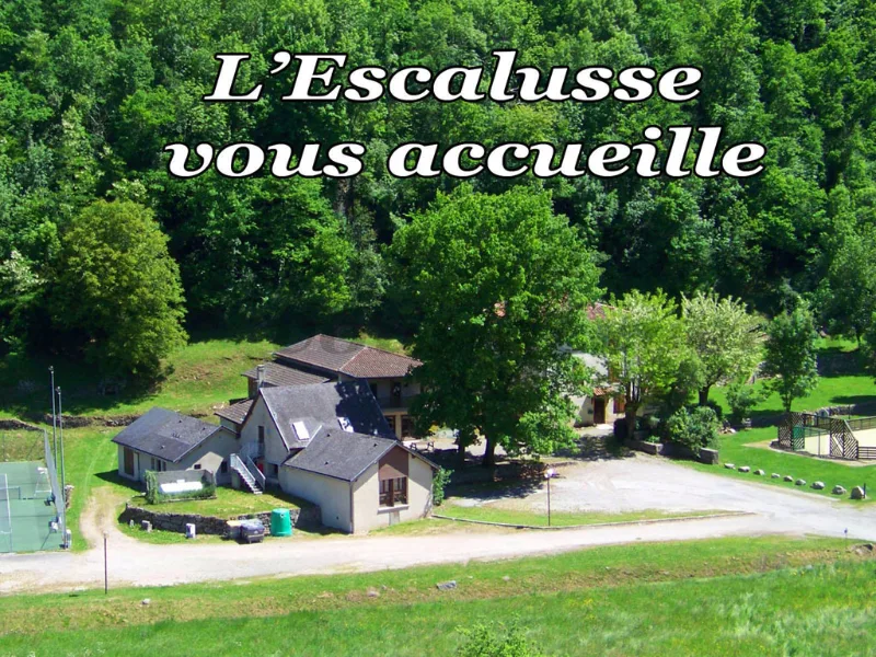 Vue aérienne du domaine L'Escalusse montrant plusieurs bâtiments en pierre au milieu de prés verdoyants et de forêts