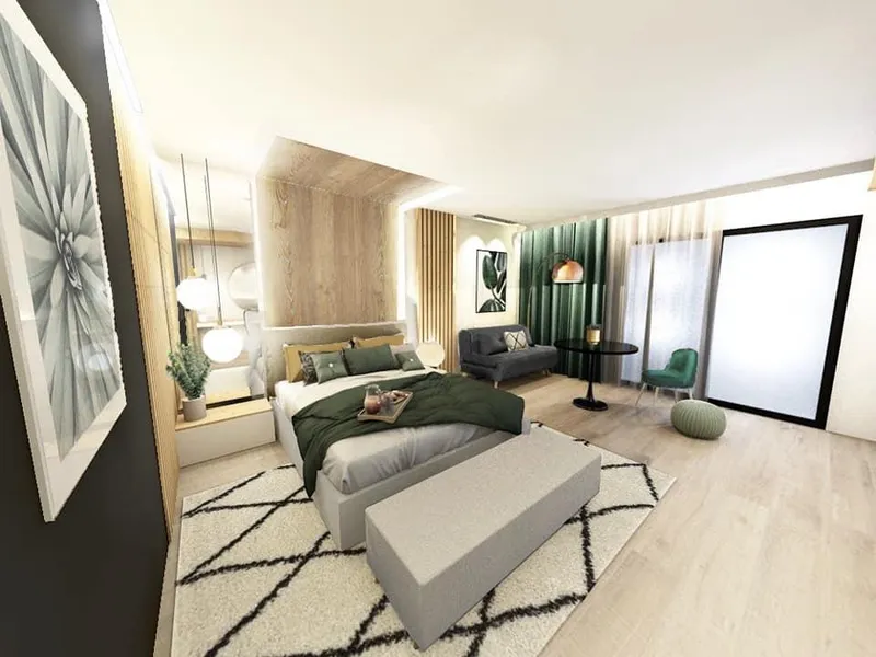 Chambre spacieuse avec grand lit habillé de linge vert et blanc, parquet clair et fauteuil vert