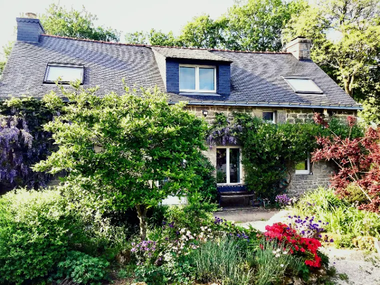 Façade du gîte Les Piléas avec glycine en fleur et jardin luxuriant