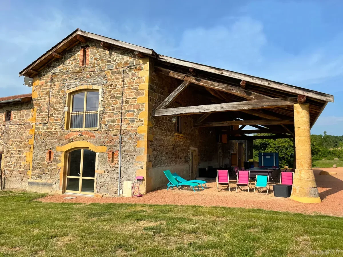 Gîte de groupe Domaine du Buisson à Sarcey — Espace extérieur couvert avec chaises longues turquoise et roses face au jardin, capacité 34 personnes