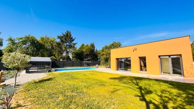 Gîte de groupe Gîte Au Petit Vivoin à Vivoin — Bâtiment orange contemporain du gîte avec piscine couverte rétractable et grande pelouse verdoyante, capacité 40 personnes