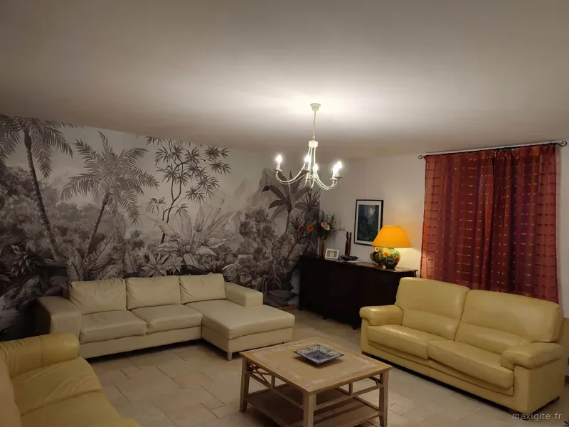 Séjour principal avec cheminée et décoration rustique en pierres et poutres apparentes